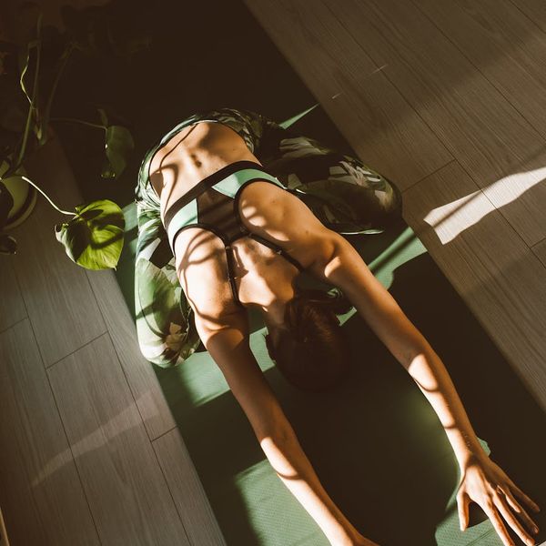 Man in activewear performing a core strength exercise at home.